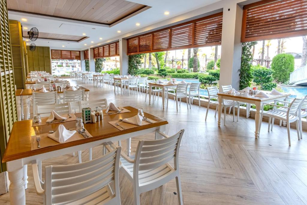 Restorāns Mirada Del Mar Hotel ar elegantām galdiem un dārza skatu.