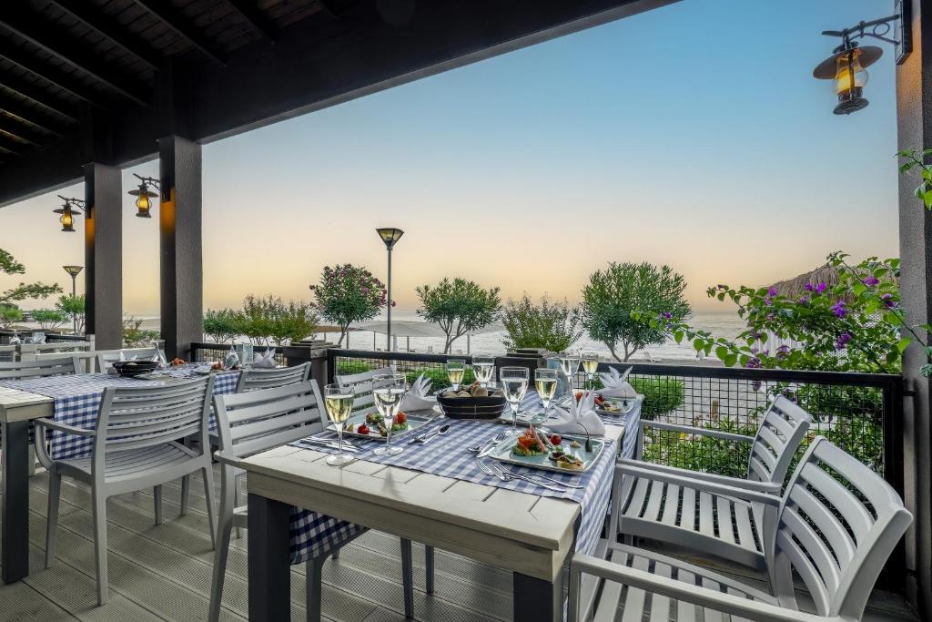 Restorāna terase piekrastē ar galdiem un skatu uz saulrietu, Mirada Del Mar Hotel.