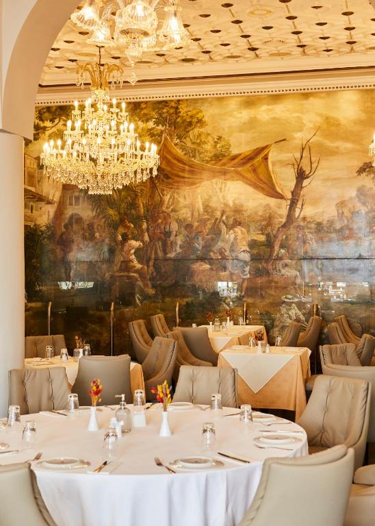 Elegants restorāns ar krāšņu lustru un gleznainu sienu, Grande Albergo Delle Rose