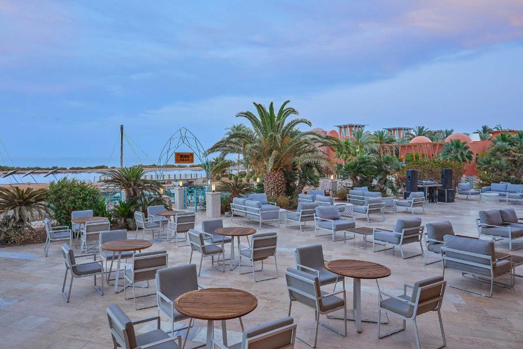 Terase pie Sheraton Miramar Resort ar ērtām mēbelēm un palmām