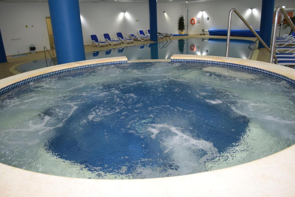 Lieliska relaksācijas zona ar burbuļvannu un peldbaseinu, kas ir ideāla vieta atpūtai un izklaidei. Moderns interjers un mierīga atmosfēra nodrošina komfortu.