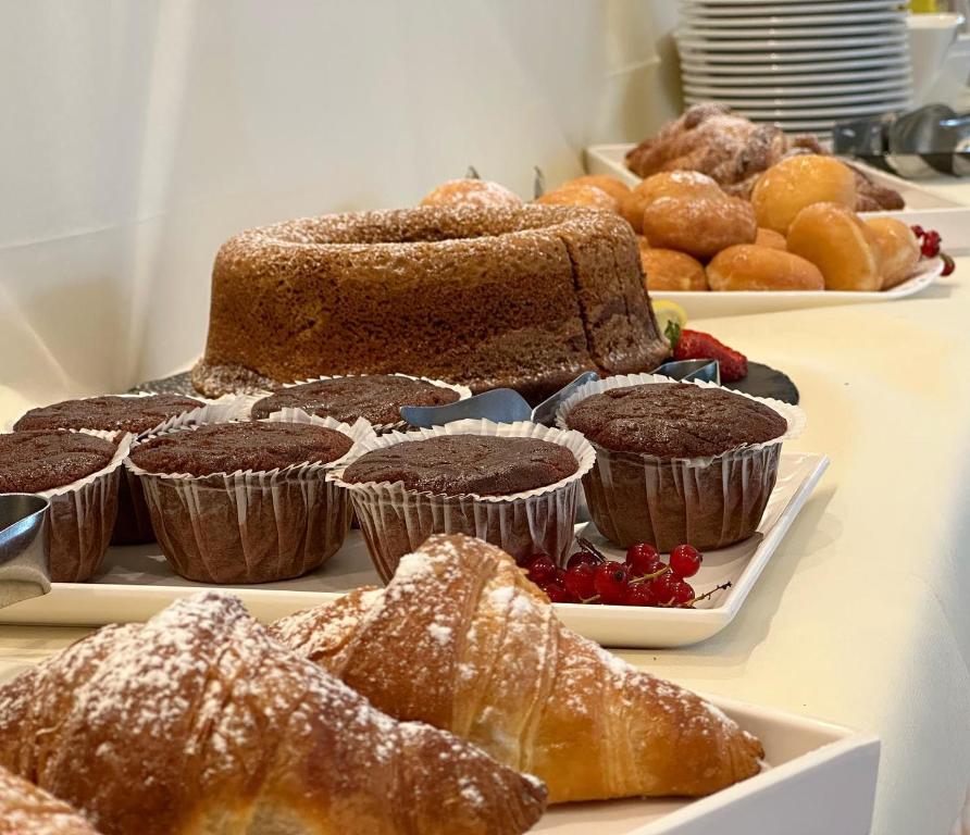 Deserts un konditorejas izstrādājumi uz galda, tostarp šokolādes keksi un gaisīgs kūka, rotāti ar pūdercukuru.