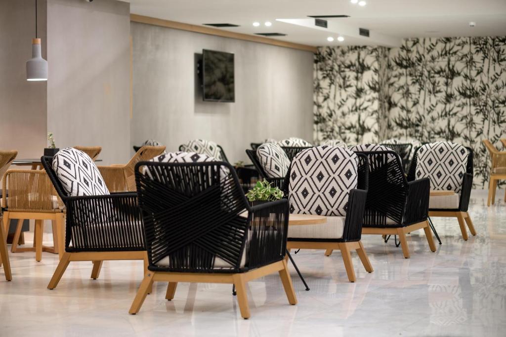 Mūsdienīga kafijas stūra ar stilīgiem krēsliem un elegantu interjeru, kas apvieno melno un balto krāsu. Ideāla vieta relaksācijai un sociālām sanākšanām.