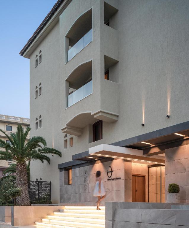 Moderns viesnīcas ieejas skats ar apgaismotām kāpnēm un palmām. Eleganta arhitektūra un viesmīlīga atmosfēra.