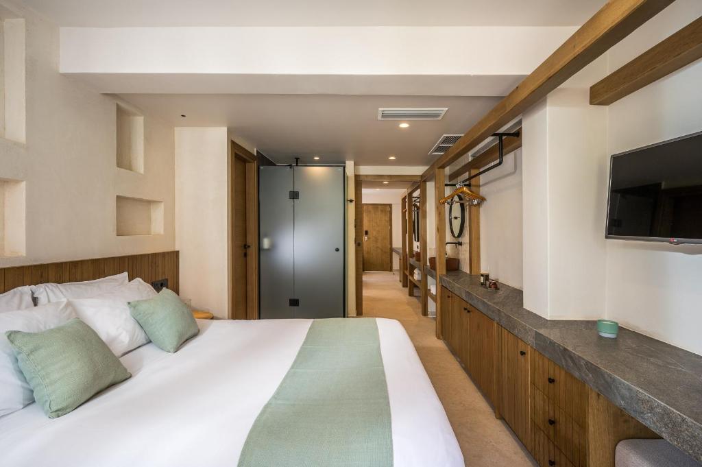 Mūsdienīgs viesnīcas numurs ar ērtu gultu, dekorētu ar zaļām spilveniem, un koka mēbelēm, kas rada siltu atmosfēru. Numurā ir televizors un elegants akmens galds.