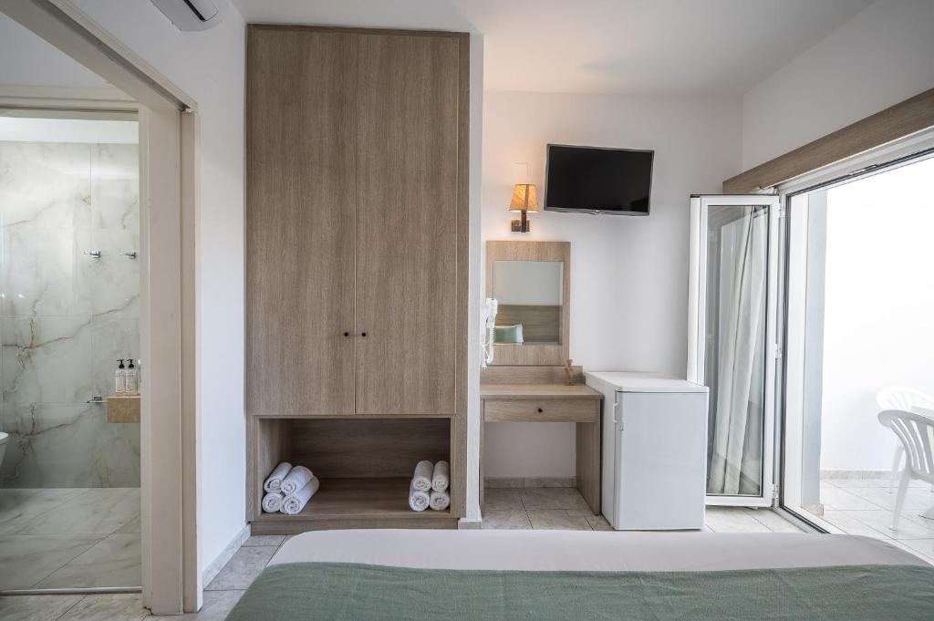 Moderns viesnīcas numurs ar gaisīgu interjeru, iekārtots ar televizoru, ledusskapi un rakstāmgaldu. Logi ved uz terasi, radot patīkamu atmosfēru.