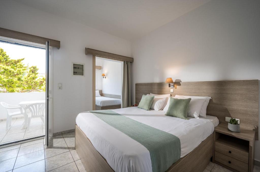 Mūsdienīga guļamistaba ar divguļamo gultu, gaišiem toņiem un pieejamu balkonu, kurā ir balta plastmasas mēbele. Guļamistabā ir arī otra gulta un liela spogulis, kas rada plašuma sajūtu.