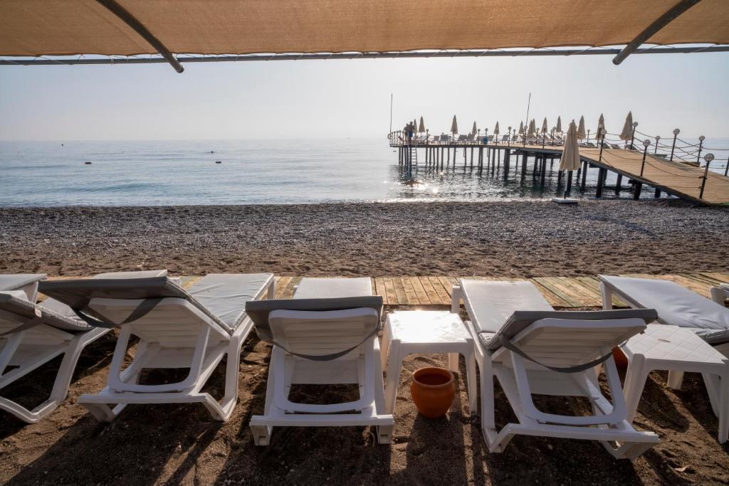 Sauļošanās krēsli pie Fore Resort & Spa pludmales, skats uz molu.