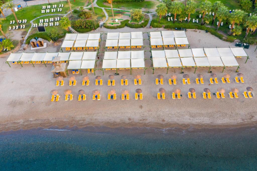 Kairaba Bodrum Imperial pludmales zona ar sauļošanās krēsliem un saulessargiem.