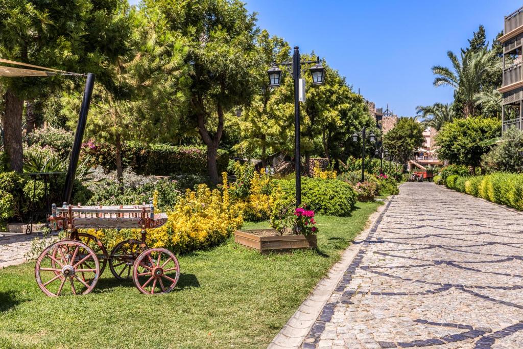 Kairaba Bodrum Imperial dārza ainava ar ziediem un akmens ceļu.