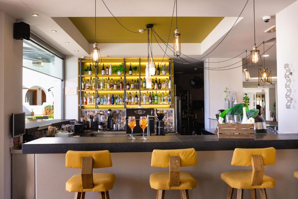Mūsdienīgs bārs ar dzeltenām krēsliem, stilīgu apgaismojumu un plašu dzērienu izvēli. Interjers ir gaišs un aicinošs, radot patīkamu atmosfēru.
