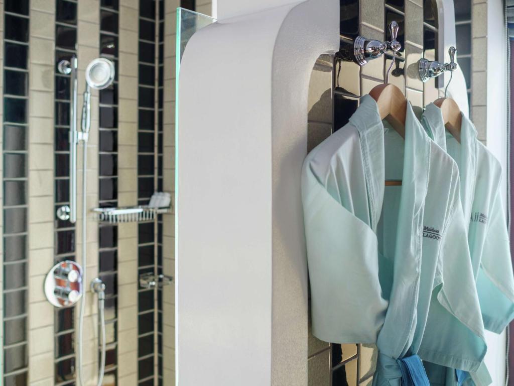 Luksusa vannas istaba ar diviem gaiši ziliem halātiem, kas pakārti uz āķiem, un dušas kabīni ar moderniem santehnikas elementiem.