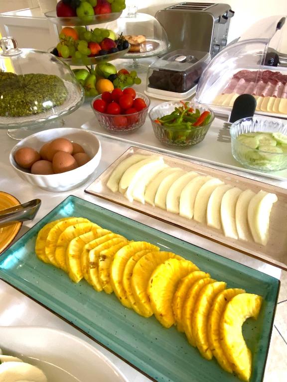 Broka ar dažādiem augļiem, dārzeņiem un olām, ieskaitot ananāsu šķēles un salātu bļodu, kas atspoguļo veselīgu brokastu izvēli.