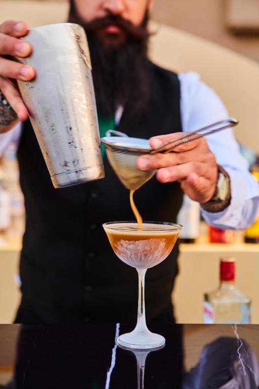 Bārmenis lej kokteili no šejkera Grande Albergo Delle Rose.