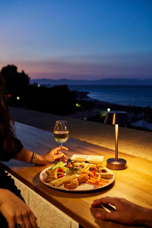 Elegants ēdiens un vīns pie Grande Albergo Delle Rose, saulrieta fons