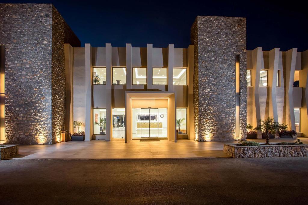 Mūsdienīgs viesnīcas Lardos Bay eksterjers naktī ar akmens elementiem
