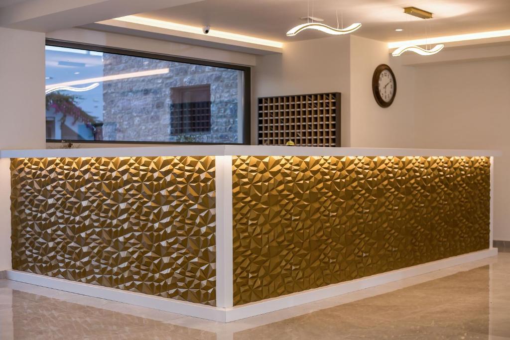 Mūsdienīgs reģistratūras galdiņš viesnīcā Lardos Bay ar dekoratīvu zelta apdari.