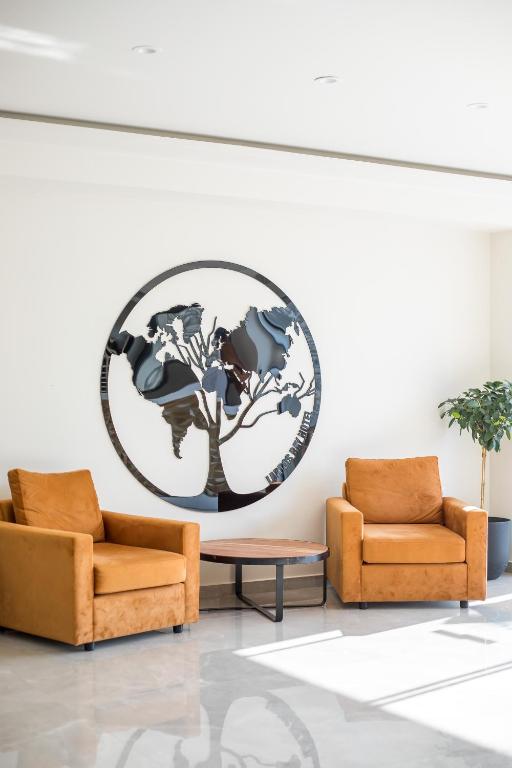 Mūsdienīga atpūtas zona viesnīcā Lardos Bay ar oranžām krēslām.