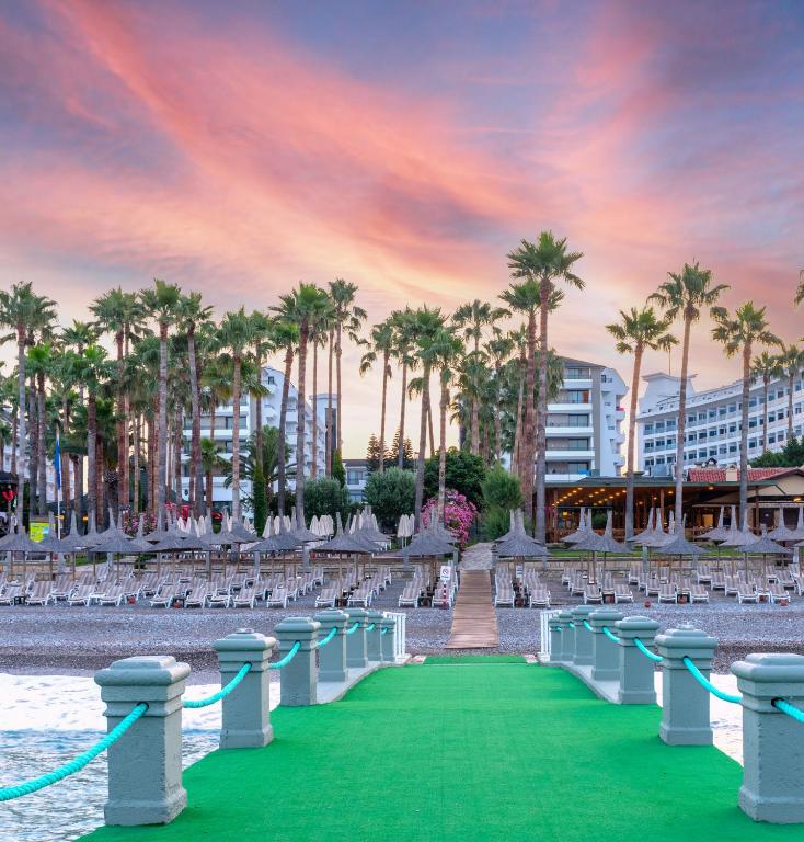 Meryan Hotel piekrastē ar palmām un saulrietu