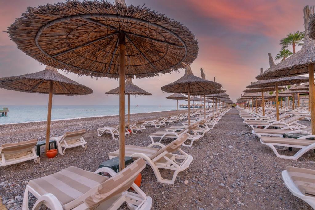 Meryan Hotel pludmales zona ar saules krēsliem un lietussargiem piekrastē