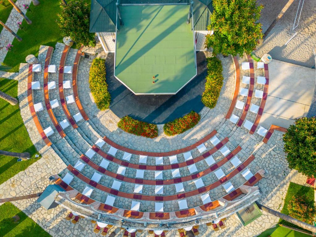 Meryan Hotel amfiteātris ar baltām krēslām un zaļām ainavām