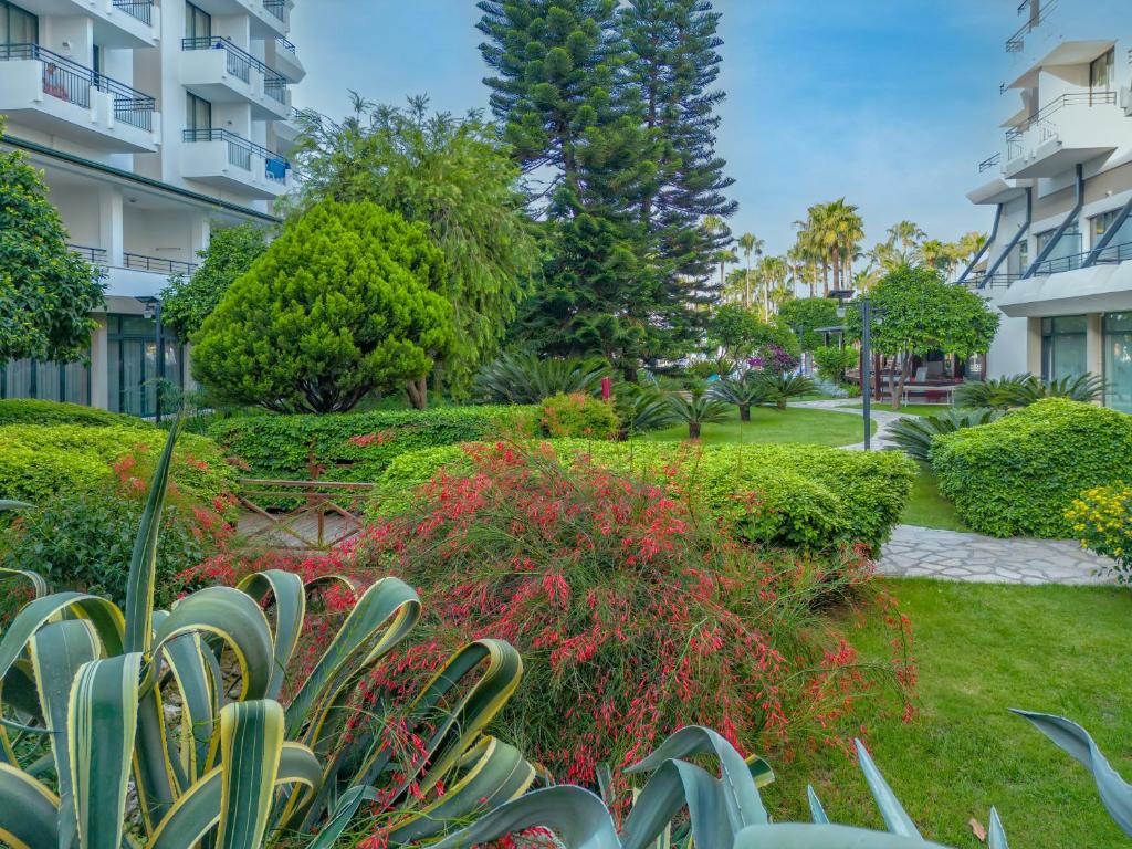 Meryan Hotel dārzs ar zaļām zonām un ziediem