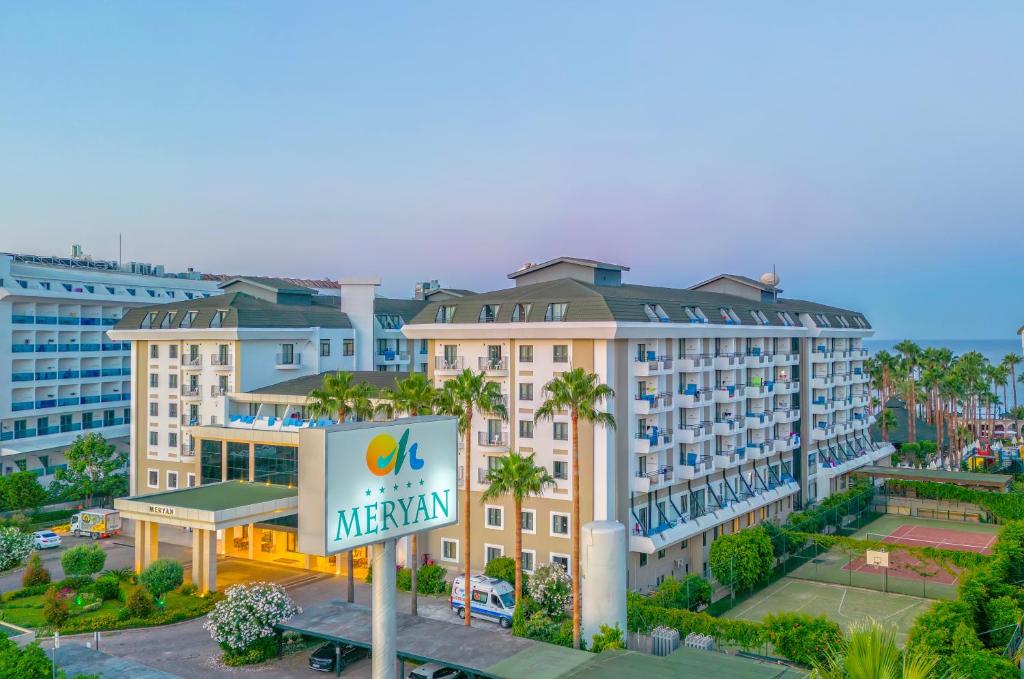 Meryan Hotel ārskats ar zaļiem dārziem un sporta laukumiem piekrastē