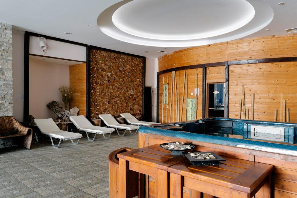 Mūsdienīga spa telpa ar koka apdari, atpūtas krēsliem un džakuzi, kas radīta relaksācijai un komfortam. Dabas elementi un siltas krāsas piešķir atmosfēru mieram.