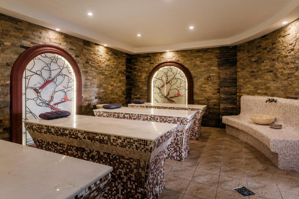 Spa telpa ar mūsdienīgu dizainu, akmens sienām un mozaīkas galdiem, kas aicina uz atpūtu un relaksāciju. Sienā ir izsmalcināts vitrāžas elements ar putniem.