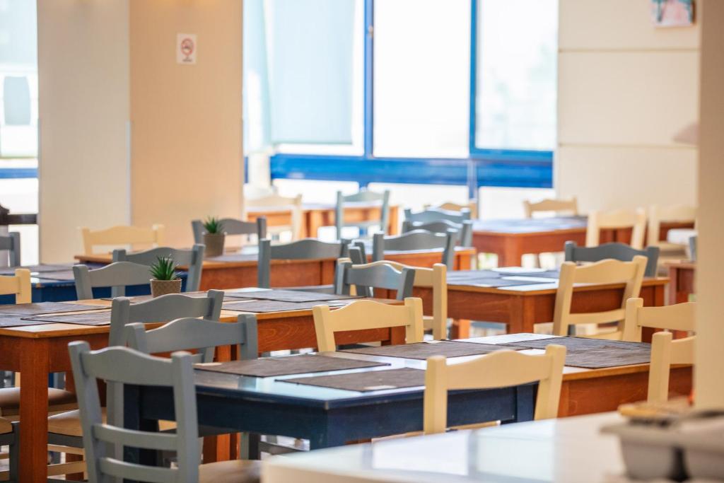 Bali Beach Hotel restorāns ar koka galdiem un krēsliem