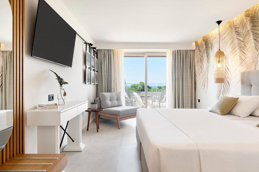 Mūsdienīgs viesnīcas numurs ar plašu logu, ērtu gultu un skatu uz jūru. Interjers ir gaišs un elegants, ar dabīgiem elementiem un modernu aprīkojumu.