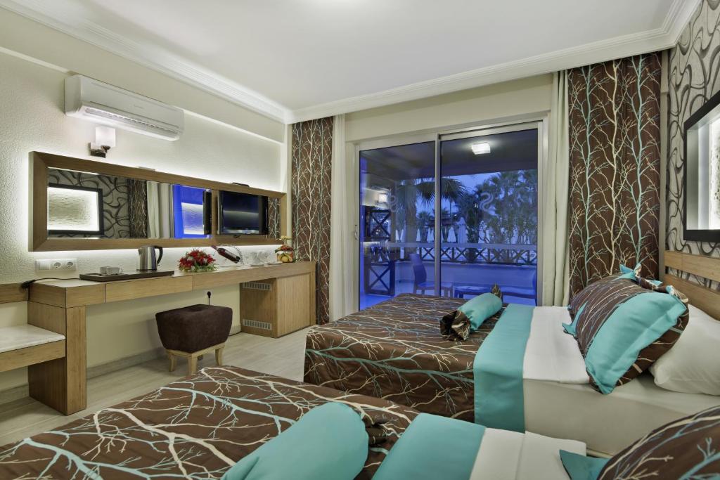 Saphir Hotel & Villas moderns numurs ar diviem gultām un skatu uz terasi.