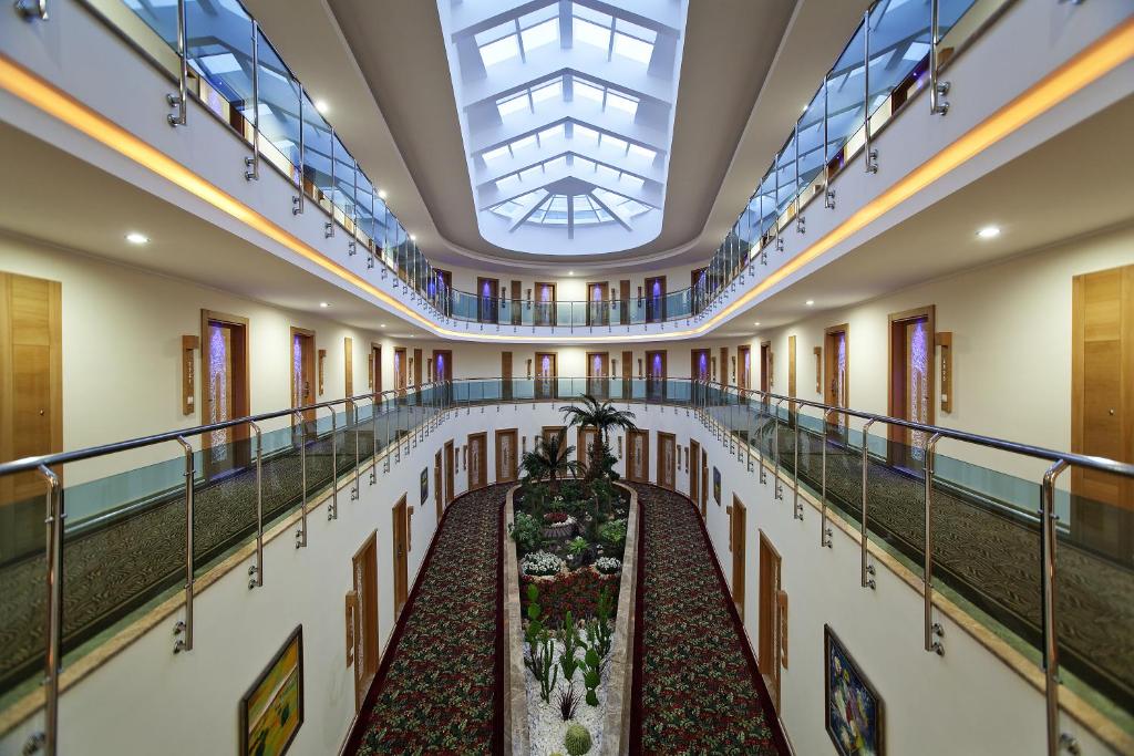 Saphir Hotel & Villas interjers ar atvērtu gaismas telpu un augiem.
