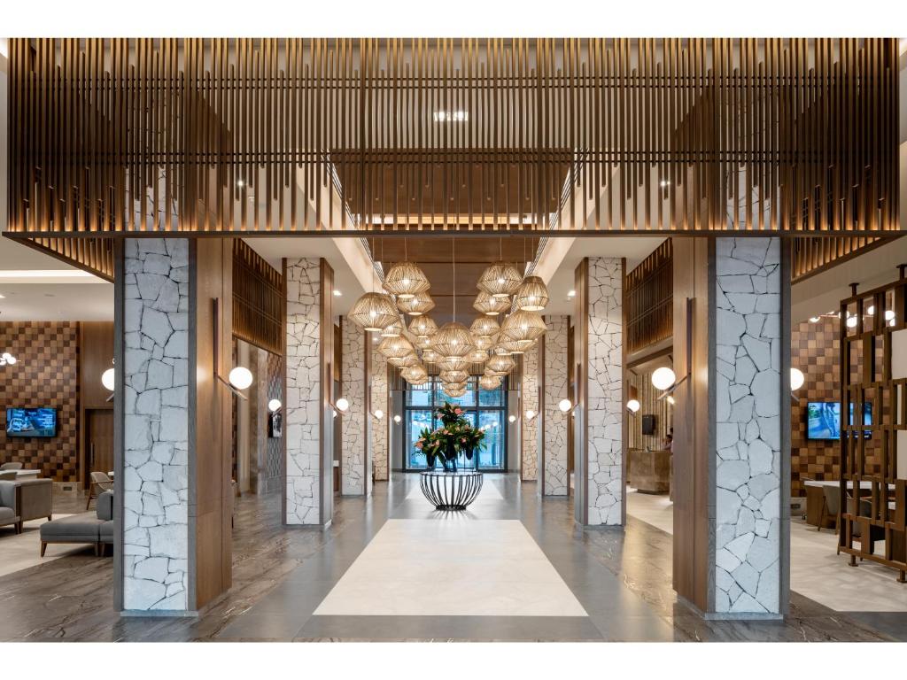 Mūsdienīgs un elegants ieeja Swandor Hotels & Resorts ar apgaismojumu un ziedu kompozīciju.