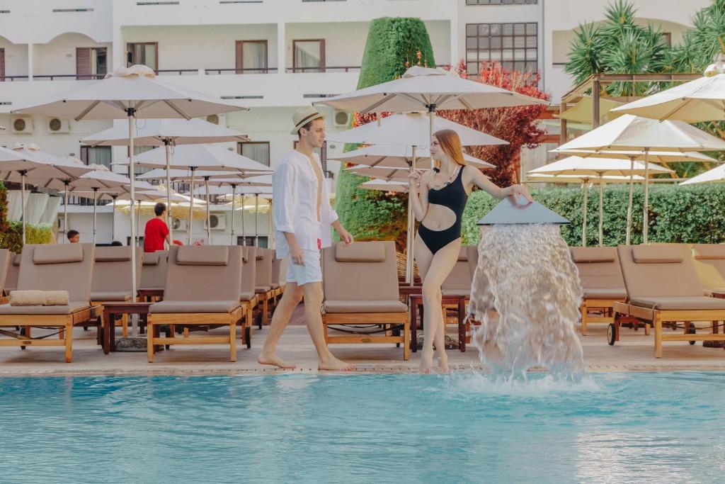 Jauni pāri pie Albatros Spa & Resort, baudot baseinu un sauli.