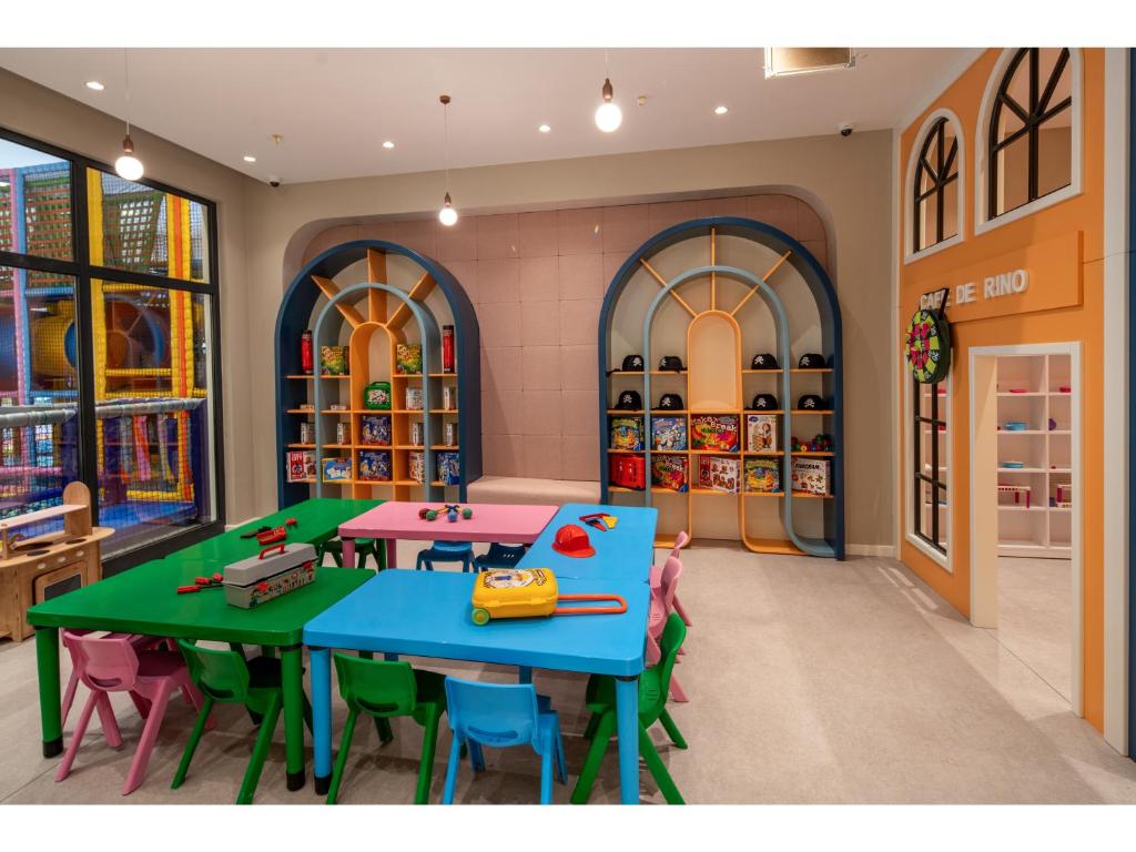 Bērnu spēļu telpa Swandor Hotels & Resorts ar krāsainām galdiem un rotaļlietām.