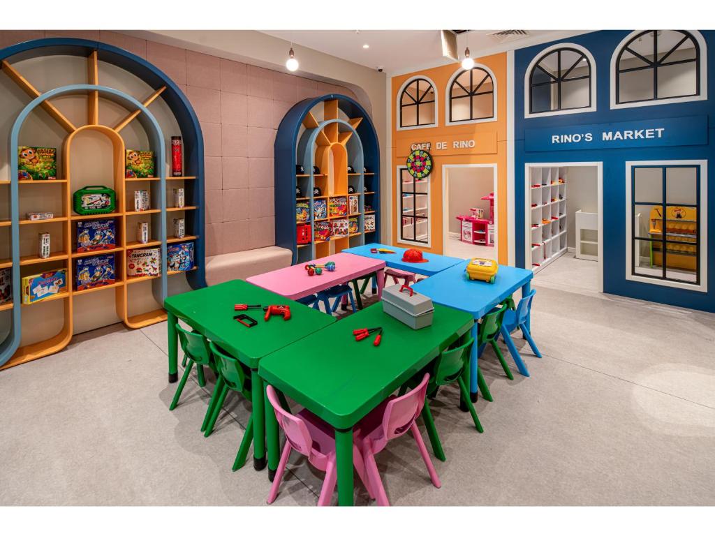 Bērnu rotaļu istaba Swandor Hotels & Resorts ar galdiem un plauktiem spēlēm.