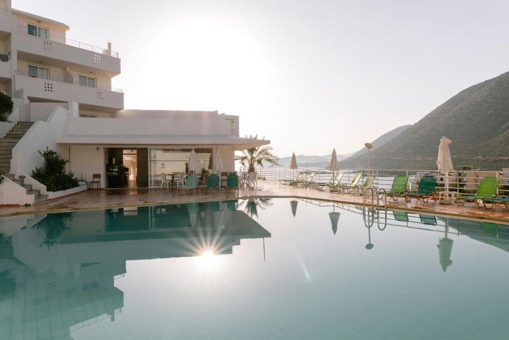 Bali Beach Hotel baseins ar sauli un kalniem fonā