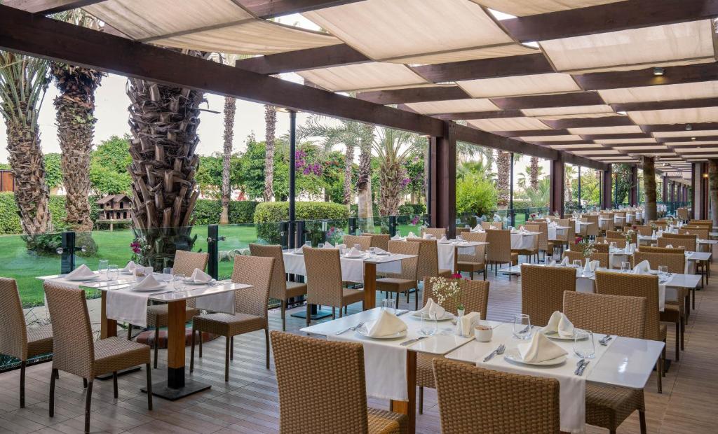 Kaya Belek restorāns ar galdajiem un palmām piekrastē