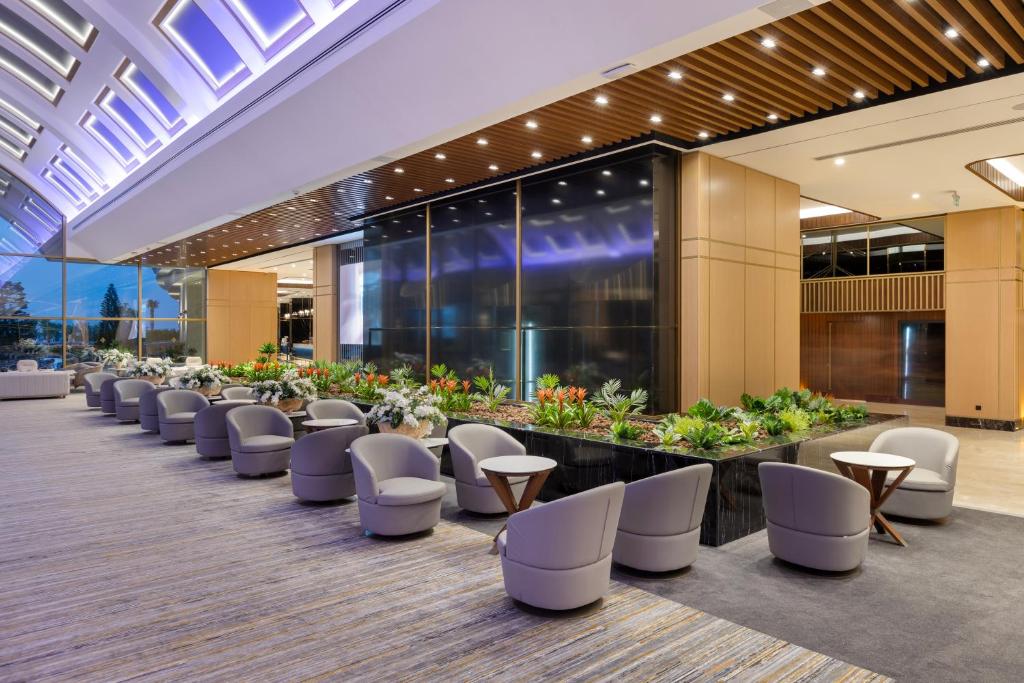 Mūsdienīgs atpūtas stūris Miracle Resort Hotel ar zālēm un ērtām krēsliem.