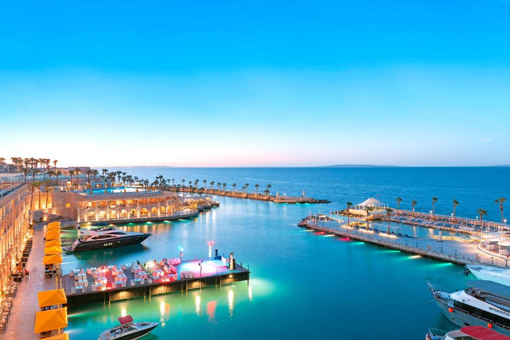 Skats uz Pickalbatros Citadel Resort piekrasti un ostu saulrietā.