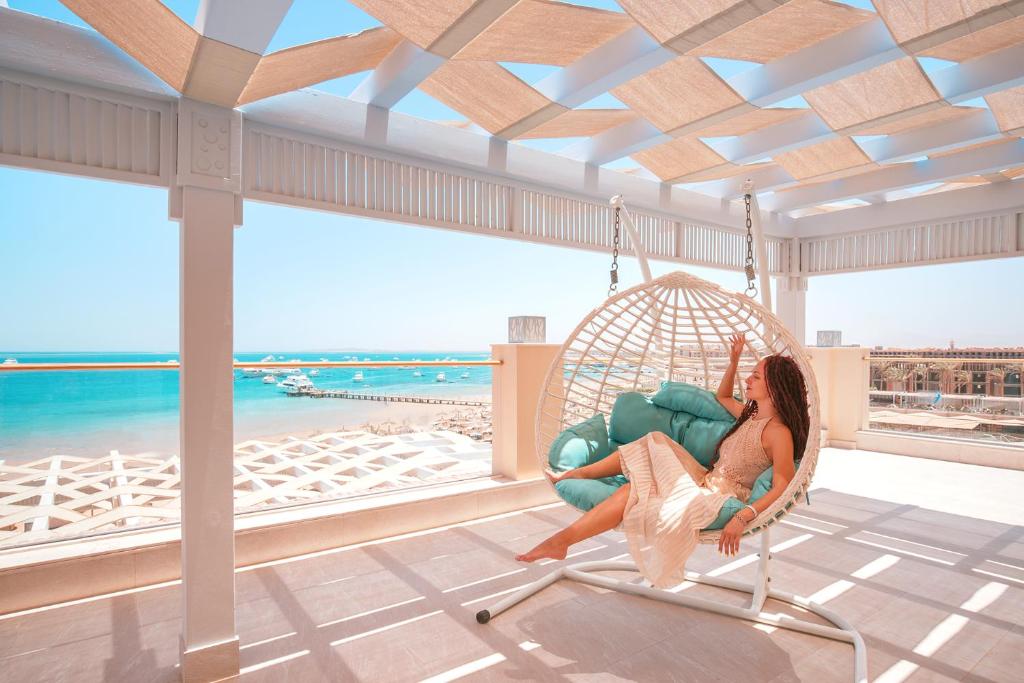 Sieviete šūpuļtīklā ar skatu uz jūru Albatros White Beach Resort.