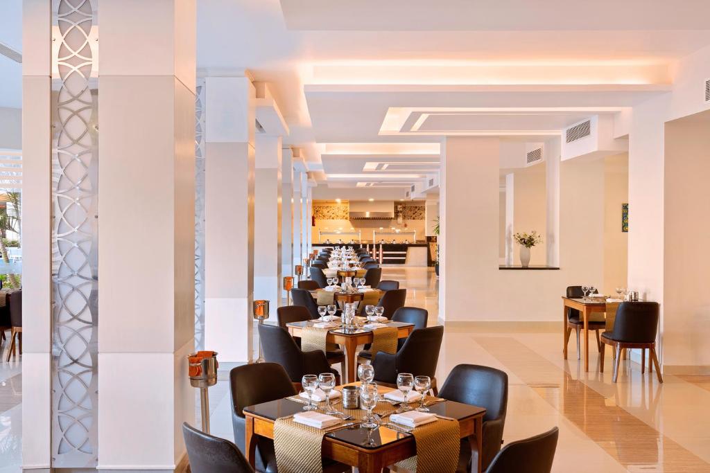 Eleganti restorāna interjers Albatros White Beach Resort ar stilīgiem galdiem.