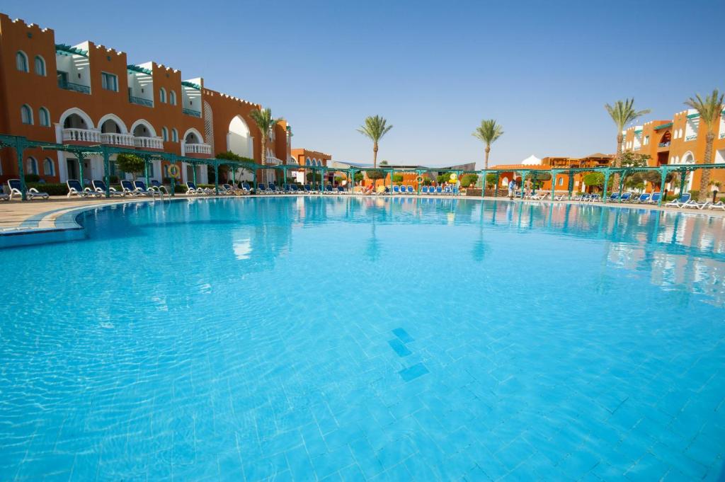 Viesnīcas Sunrise Garden Beach Resort peldbaseins ar saulainu laiku un palmu kokiem.