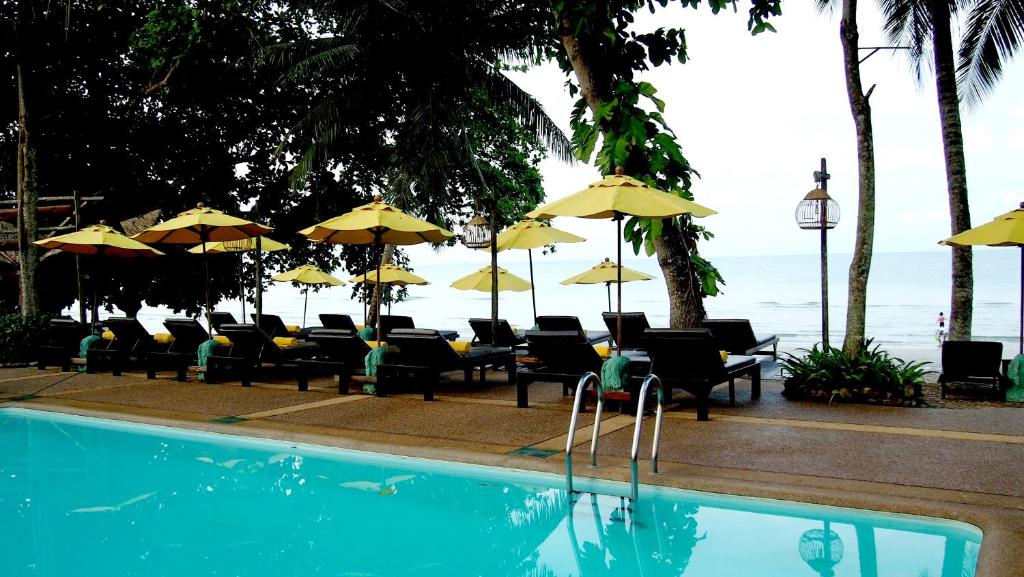 Viesnīcas Banpu Koh Chang baseins ar saulessargiem piekrastē