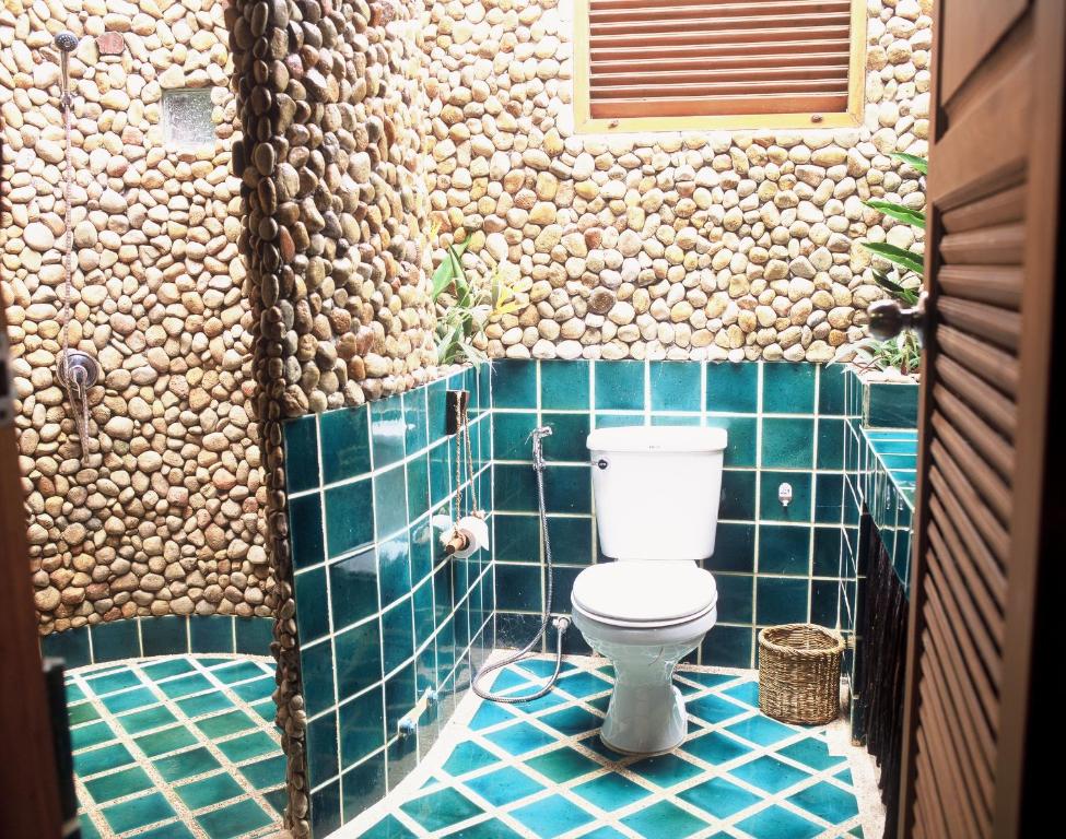 Moderns vannas istabas dizains Banpu Koh Chang ar akmens apdari un zaļām flīzēm.