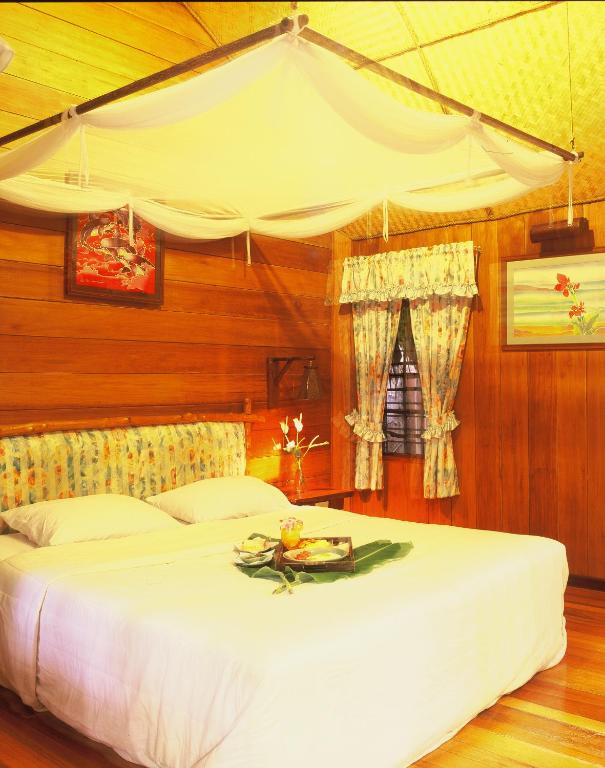 Mierīga numura atmosfēra Banpu Koh Chang ar koka sienām un dekoratīvām detaļām.