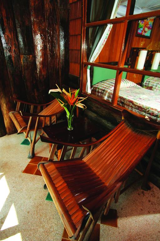 Koka krēsli un puķe pie galda Banpu Koh Chang numurā