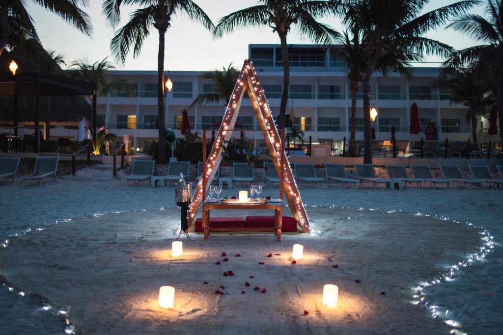 Romantiska maltīte pludmalē pie Cancun Bay Resort, apgaismota ar gaismām.
