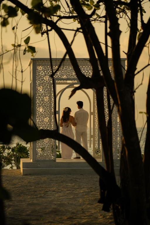 Jaunlaulāto pāris pie altāra Ifuru Island Maldives pludmalē.